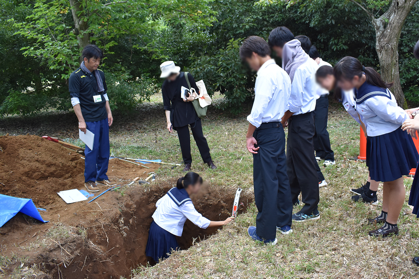 生徒さんが穴の中で土の表面を削っているところ